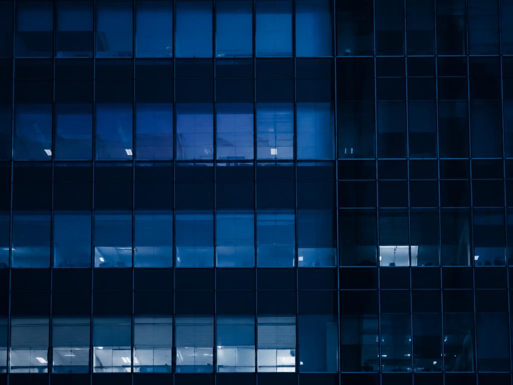 A grid of office windows lit at night